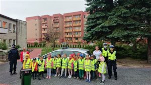 Dzieci w kamizelkach odblaskowych z policjantami na dworze