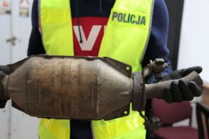 policjant trzyma odzyskany katalizator