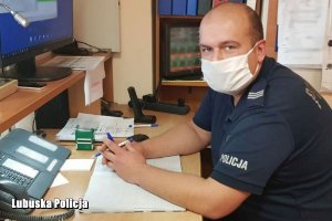 policjant siedzi przed monitorem komputera