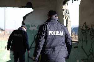 umundurowany policjant stoi przed budynkiem