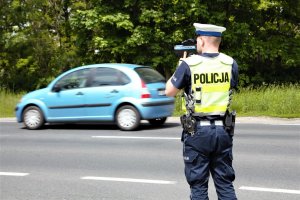 policjant ruchu drogowego i niebieski samochód