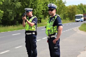 policjanci w umundurowaniu mierzą prędkość