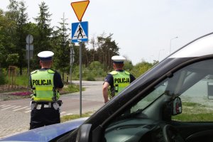 policjant ruchu drogowego stoi przy pasach