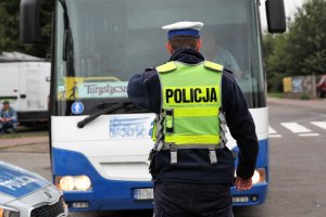 policjant w mundurze przed autobusem