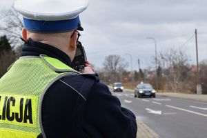 policjant ruchu drogowego trzyma miernik prędkości