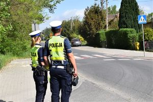 policjantka i policjant ruchu drogowego stoją przy przejściu