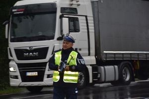 policjant przy samochodzie ciężarowym