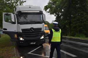 policjant kontroluje samochód ciężarowy