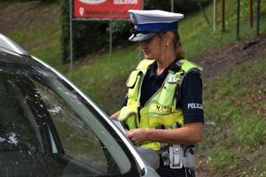 policjantka przy samochodzie podczas kontroli drogowej