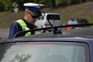 policjant ruchu drogowego kontroluje pojazd