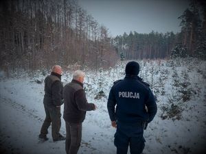 policjant i strażnicy leśni w lesie