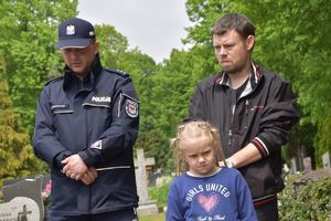 policjant i rodzina przy grobie