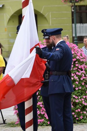 policjant w mundurze trzyma flagę