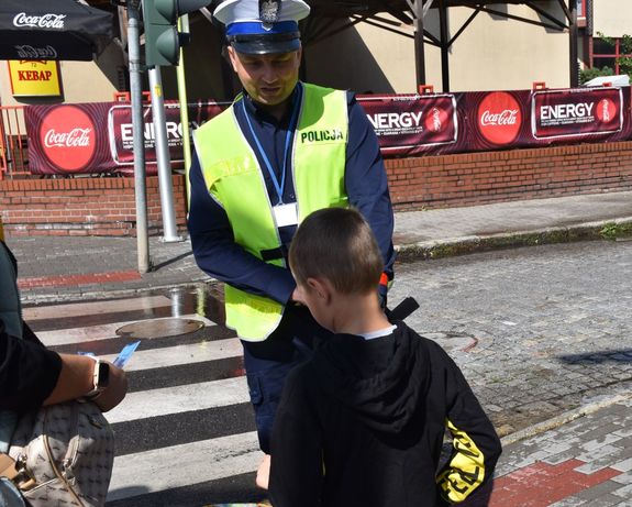 policjant z chłopcem przed przejściem