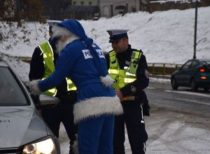 polikołaj i policjanci ruchu drogowego przy aucie