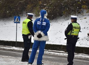 policjanci ruchu drogowego i polikołaj stoją przy drodze