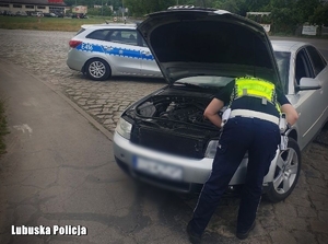 policjant wymienia żarówkę