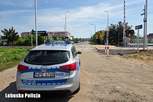 radiowóz policyjny przy przejeździe kolejowym