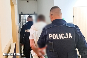 policjanci prowadza zatrzymanego